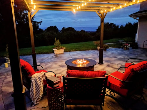 Stamped concrete patio with pergola and fire pit at dusk