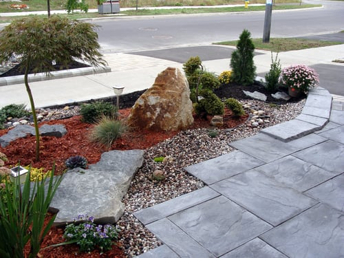 Stamped concrete walkway with stone landscaping